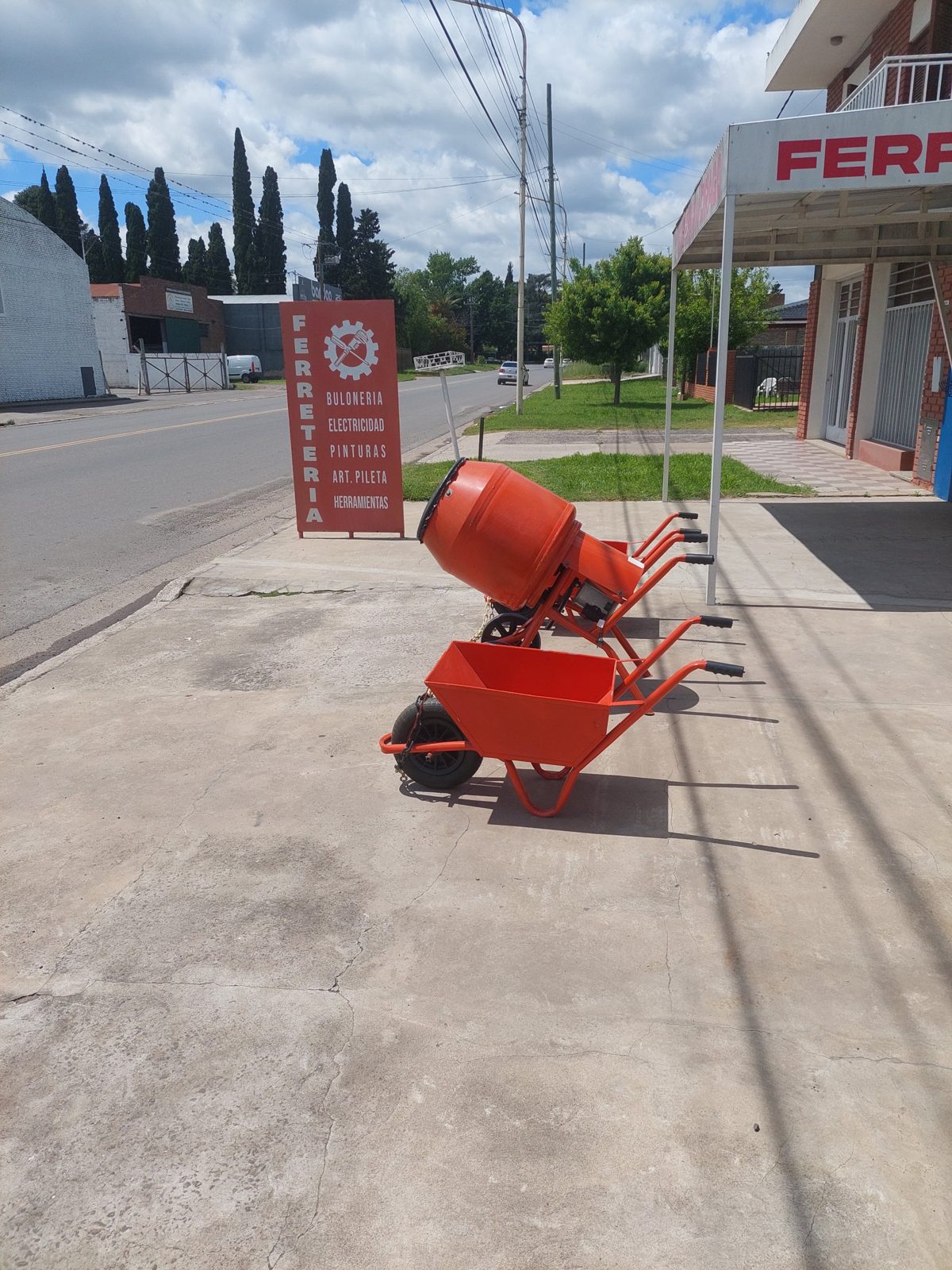 Hormigonera y carretillas frente a Ferretería Drago con el cartel del local
